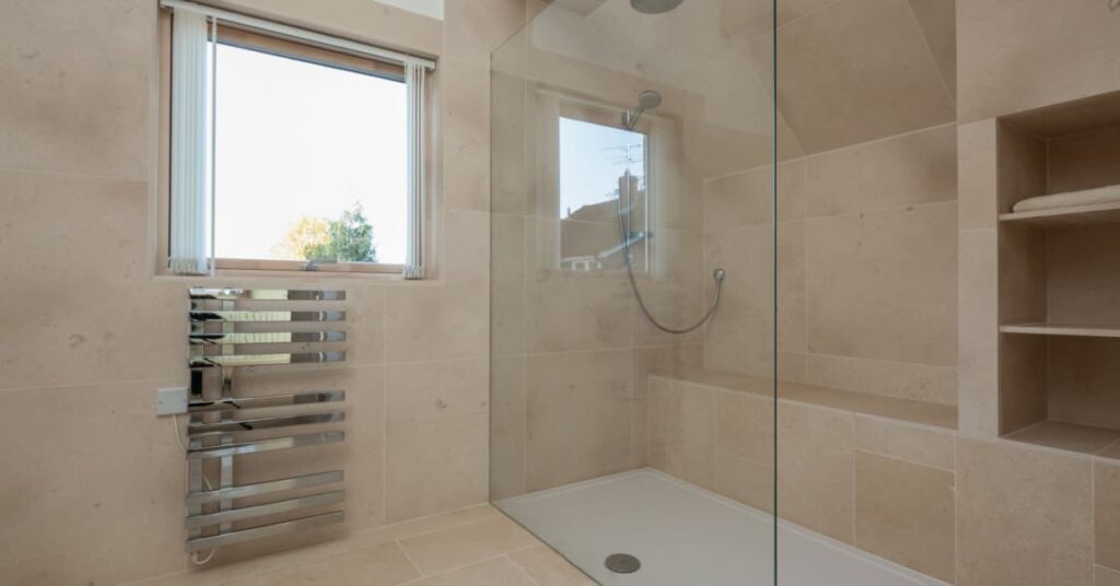 douche à l'italienne avec une grande baie vitrée et un carrelage beige dans une salle de bain moderne