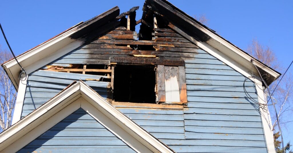 Maison en bois bleu clair endommagée par un incendie