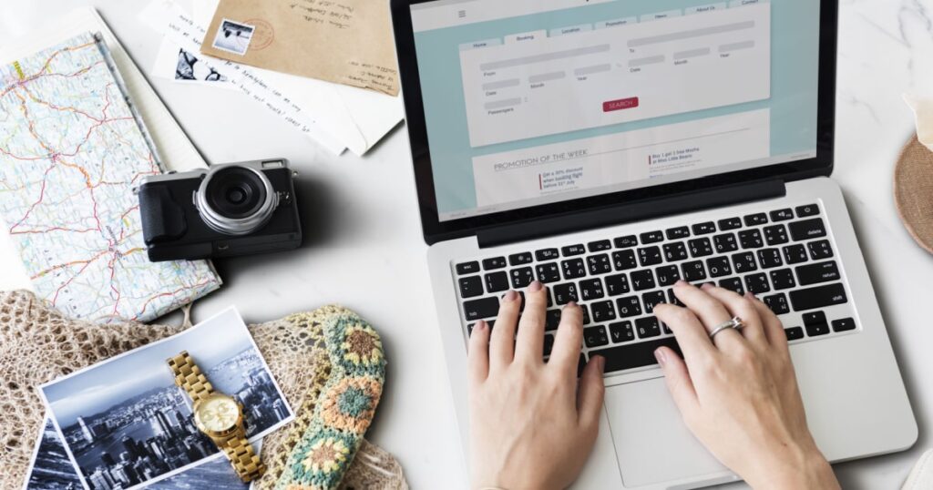 femme tapant sur le clavier de son ordinateur portable pour acheter ses billets de transport pour son prochain voyage