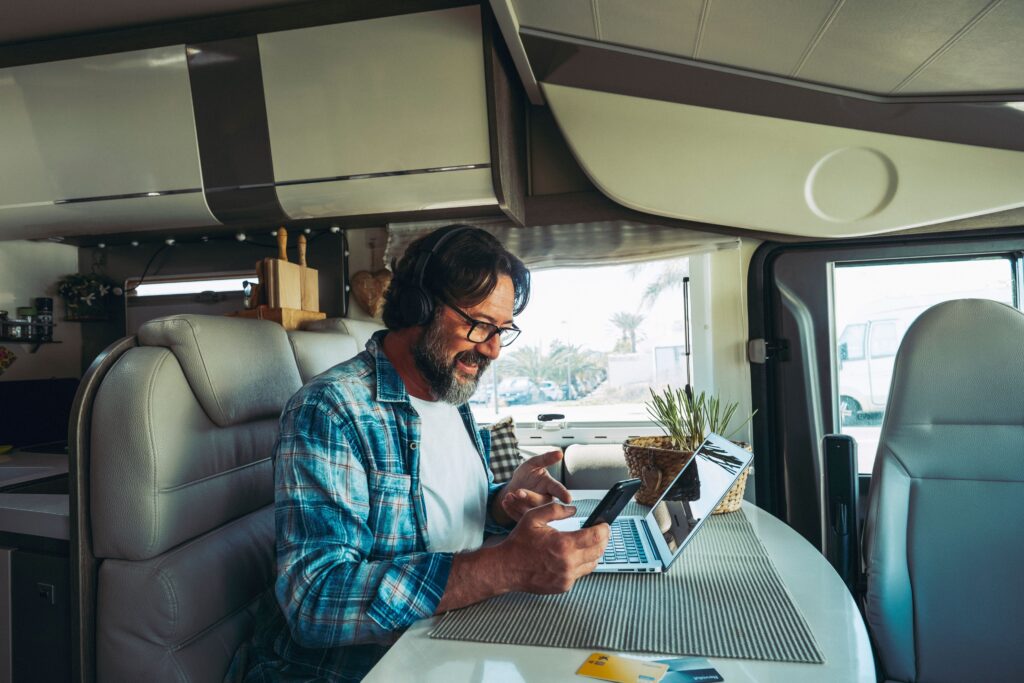 homme voyageant dans un camping car en train de réserver ses activités en ligne pour son voyage