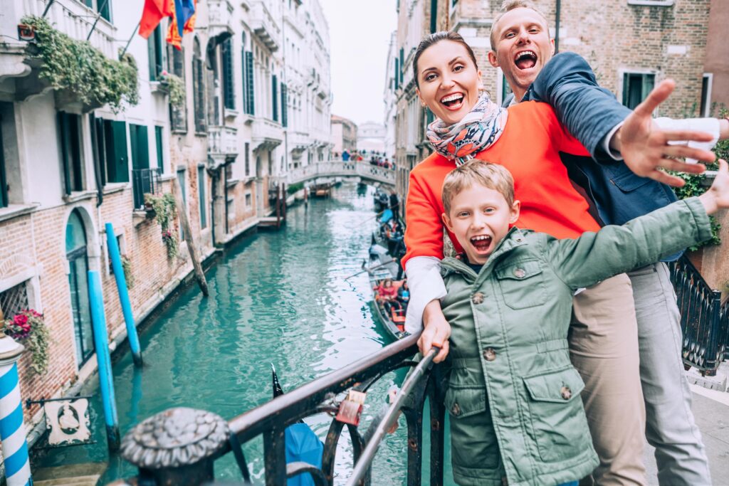 selfie d'un couple et un enfant en city trip devant des canaux